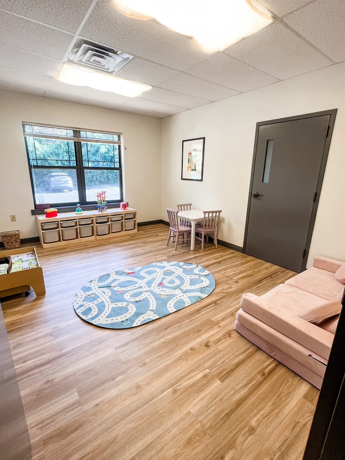 Building room with a round rug and toy bins at Latitude's Bridgeton ABA center