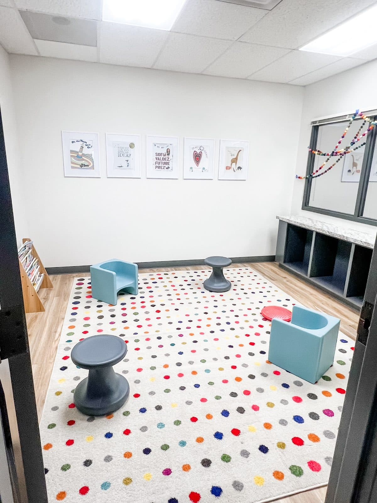 Dotted rug and child-sized seats in a circle time room at Latitude's Bridgeton ABA center
