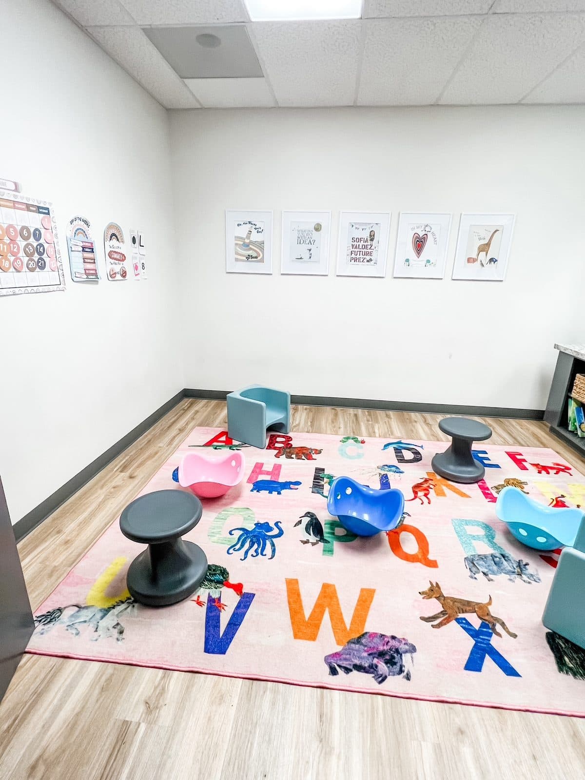 Alphabet rug and wobble stools in the circle time room at Latitude's Bridgeton ABA center