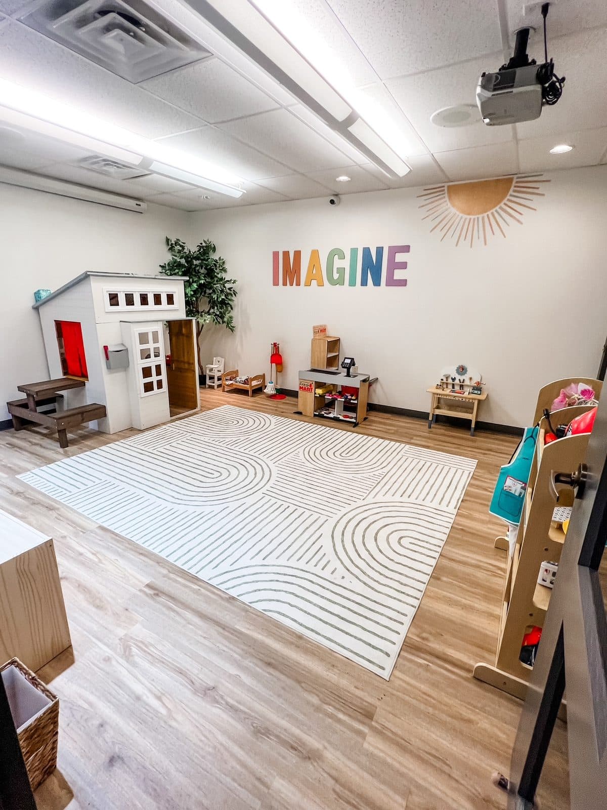 Playhouse, play kitchen and rug in the Imagine room at Latitude's Bridgeton ABA center